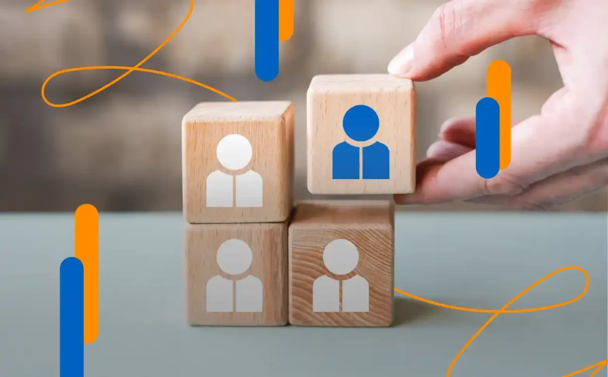 Mano colocando un bloque de madera sobre otros bloques, simbolizando la transformación digital en recursos humanos mediante procesos automatizados y centrados en el talento humano